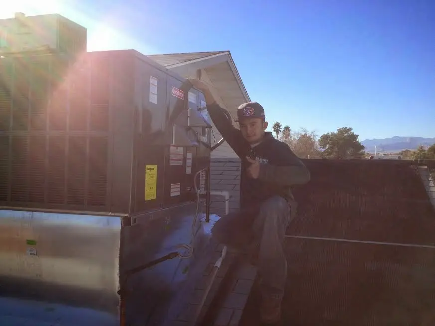 HVAC technician performing AC Tune-Up on a rooftop unit in Anoka